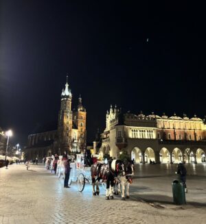 ここはクラクフ旧市街の中心にあるRynek Główny（中央市場広場）で、織物会館や聖マリア教会などが立ち並ぶ観光名所です。